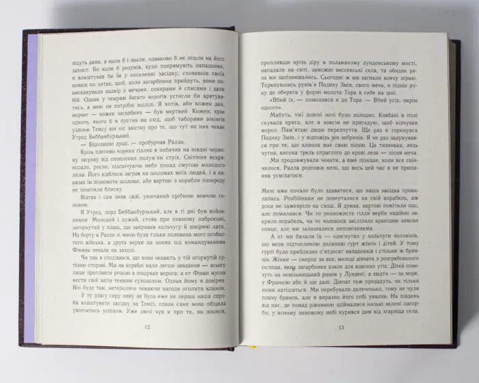 Розворот книги Пісня меча Бернарда Корнвелла з уривком тексту українського видання