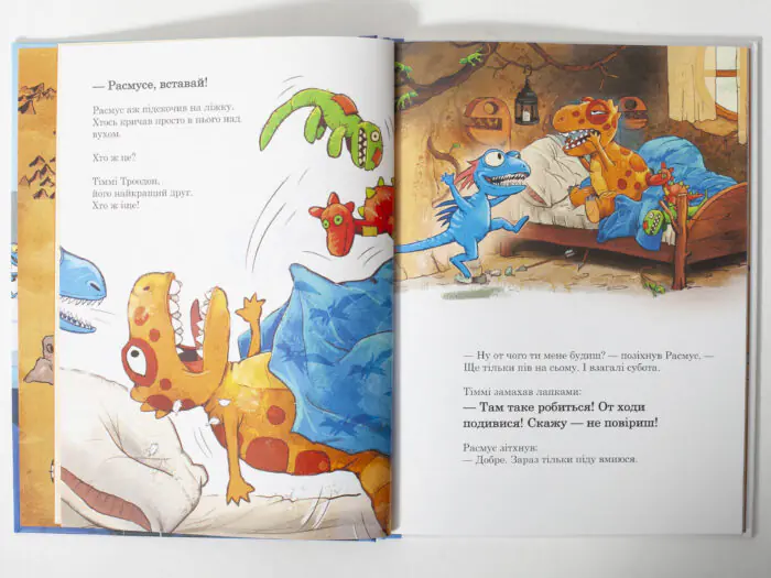 Розворот дитячої книги з динозавриками Расмус і Тіммі прокидаються