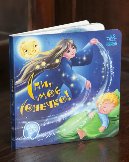 Спи моє сонечко Ірини Сонечко — книга стоїть на дерев'яній поверхні