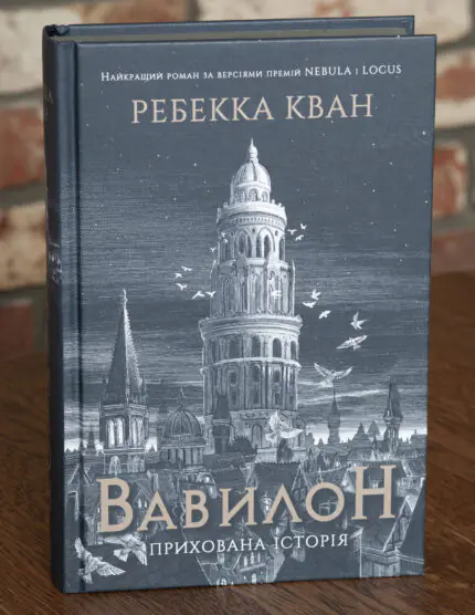 Обкладинка книги Вавилон. Прихована історія Ребекки Кван із зображенням вежі, міського пейзажу та птахів