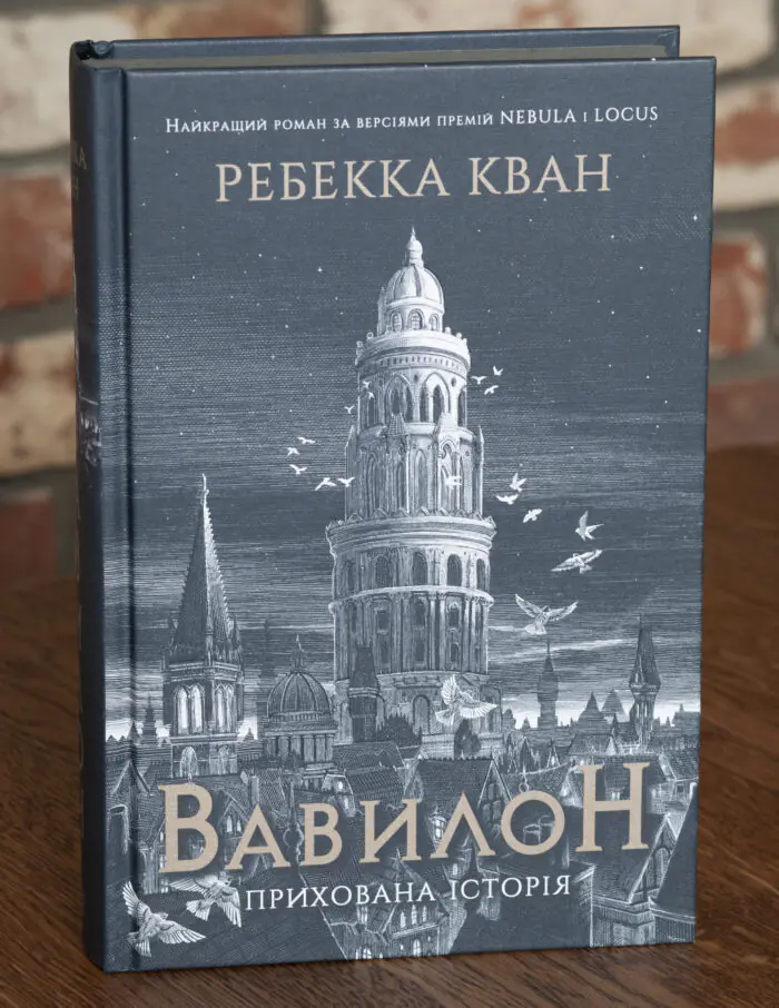 Обкладинка книги Вавилон. Прихована історія Ребекки Кван із зображенням вежі, міського пейзажу та птахів