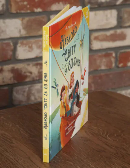 Книга «Навколо світу за 80 днів» Жуля Верна під кутом, видно корінець і тверду обкладинку