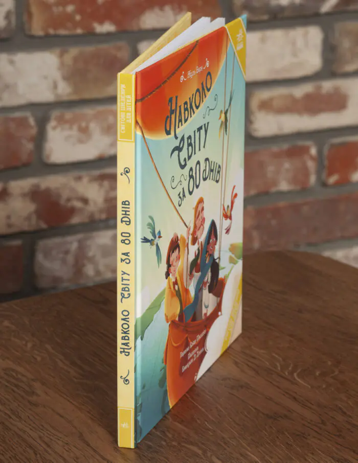 Книга «Навколо світу за 80 днів» Жуля Верна під кутом, видно корінець і тверду обкладинку