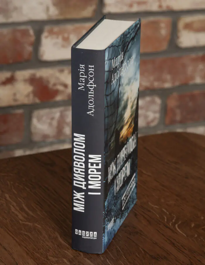 Корінець книги Між дияволом і морем Марії Адольфсон