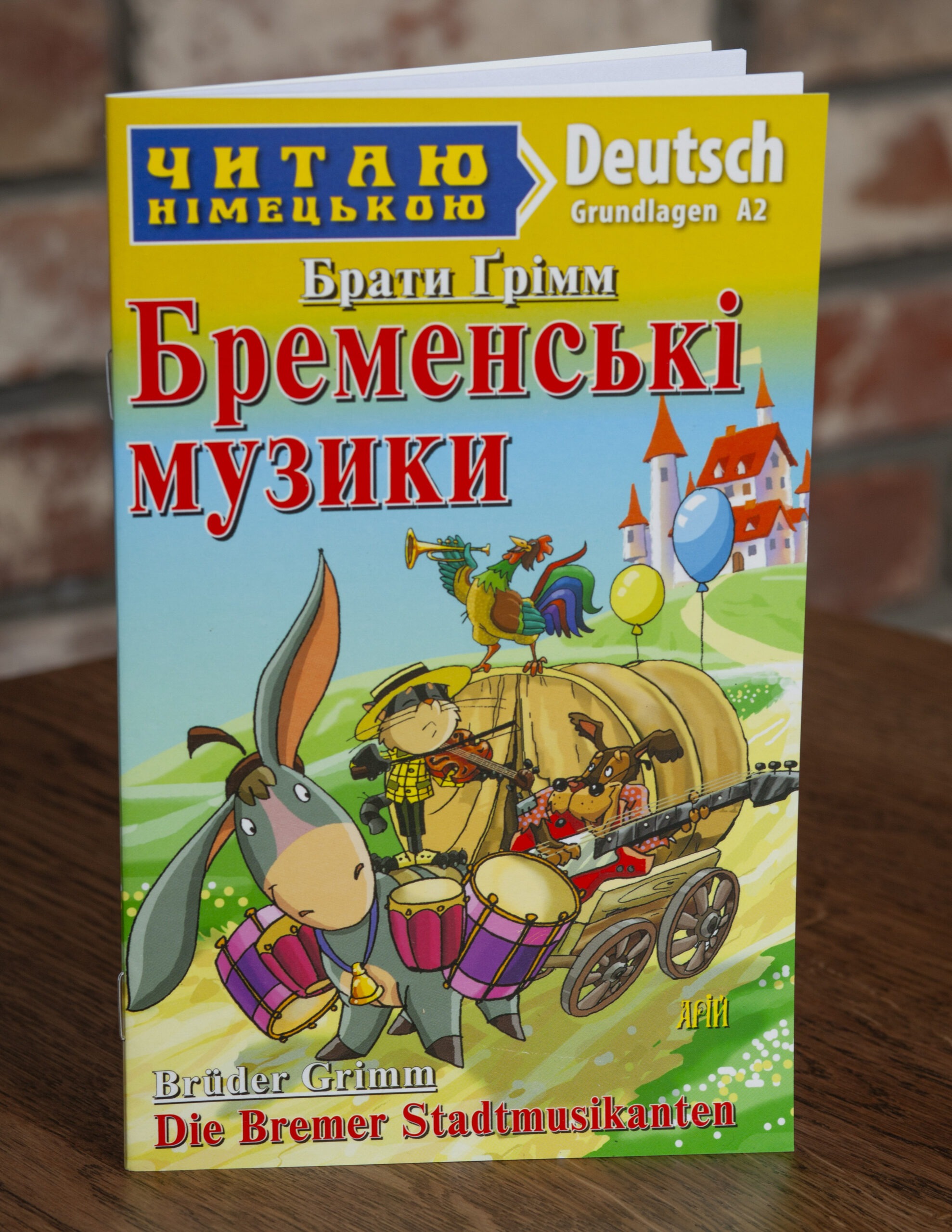 Бременські музики Німецька мова — передня обкладинка на дерев’яній поверхні Бременські музики Німецька мова — передня обкладинка на дерев’яній поверхні