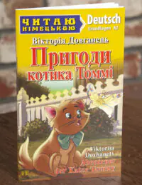 Пригоди котика Томмі Німецька мова — передня обкладинка на дерев’яній поверхні